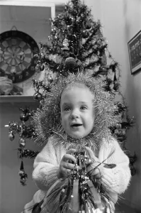 00523 Prints: Meltham Fire Station Christmas party - young girl with tinsel wrapped round her head