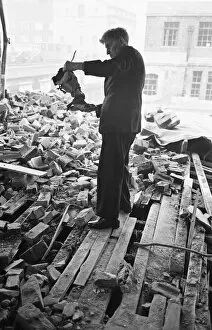 01462 Collection: A member of staff holds a damaged instrument amongst the rubble of The Westminster