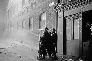 01496 Prints: Members of the Auxiliary Fire Service and London Fire Brigade seen here fighting a fire