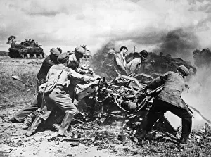 Members of the French Forces of the Interior clear away burning vehicles on the main road
