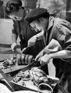 00199 Prints: Members of the Womens Voluntary Service carving a joint of meat at Old Montague Street