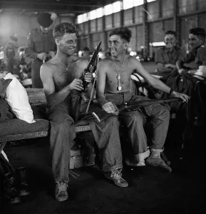 Men of the Lancashire Fusiliers camped in a hanger in Nairobi clean their weapons