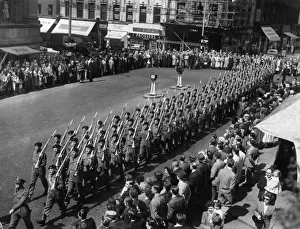 Men of the Manchester Regiment with bayonets fixed march into Cross Street on their way