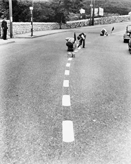 Men painting blackout lines on the road. 27th August 1939