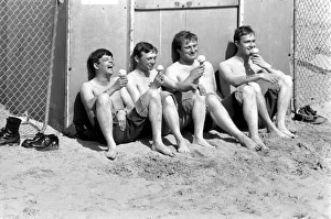 Four men sitting enjoying an ice cream in the hot weather at Margate Beach