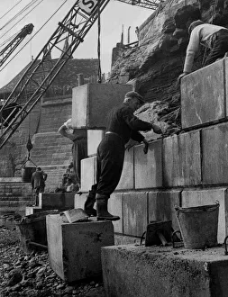 The men who are working on this wall, which is designed to prevent the sea eeating