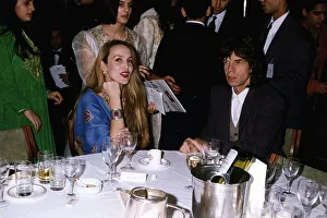 Mick Jagger Singer with wife Jerry Hall sitting at table a gala night