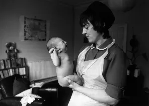 00097 Prints: Midwife Lyz Simons with new born baby at a new parents home in Bristol