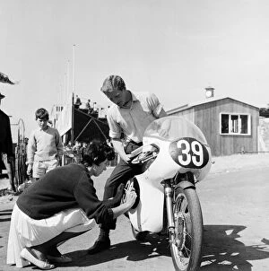 Motorbike Collection: Mike Hailwood with girlfriend Pauline Nash helping him put on his race numbers 5th