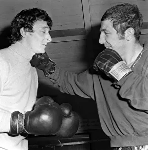 Mike Summerbee gets a right hander from heavyweight boxer Kevin Madden in the Gym where
