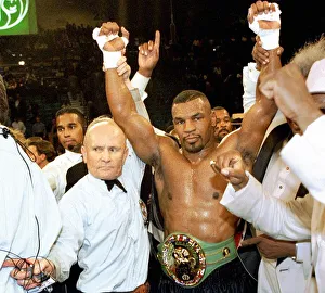Mike Tyson has his arms raised by referee Mills Lane after beating Frank Bruno for