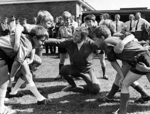 A mini scrum about to form as WRU coaching organiser Ray Williams talks to pupils