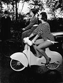 Miss Cycling 1959 riding a Scoo-ped and Miss Cycling 1898 riding an old-fashioned sit up