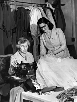 Miss Marion Agar, wardrobe mistress (right) helps Mrs May Finch, the dressmaker