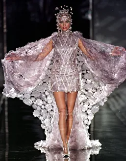 1990s Fashion Prints: Top model Adriana Karembeu sports a metallic short dress under a white cape designed by