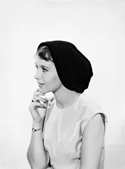 Model Ann Cave wearing a collection of spring and summer hats. Circa 1962