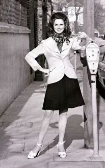 Model April Ashley wearing a white blazer polka dot scarf