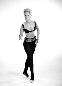 Model Brenda Bartlet dressed as Bond girl holding gun. October 1959