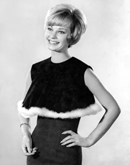 Model Dawn Chapman wearing a black sleeveless top with white fur trim