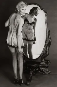 A model dressing up in 1940s style night dress with painted on seamed stockings