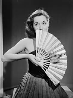 Model with fan in strapless dress. Model with fan in strapless dress. Circa 1964