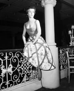 Model, Guislaine, pictured wearing a bold swoop neckline dress designed by Italian