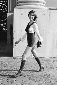 Model and horror film actress Madeline Smith poses wearing hot pants suit with knee high