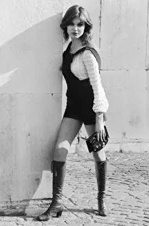 Model and horror film actress Madeline Smith poses wearing hot pants suit with knee high