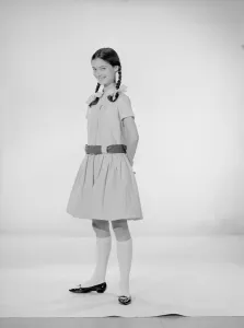 Model Jennifer Goddard. Brown-haired girl in checkered dress with pig tails