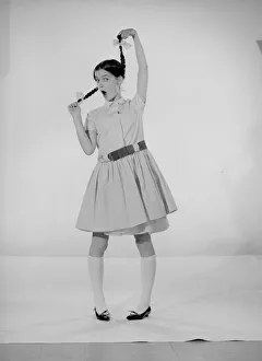 Model Jennifer Goddard. Brown-haired girl in checkered dress with pig tails
