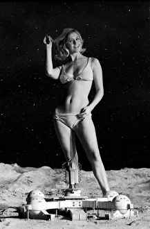 Model June Cooper poses for pictures with a backdrop designed as the surface of the moon