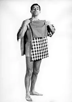 00060 Prints: Model Peter Anthony wearing a smock top holding his folded clothes and tea towels