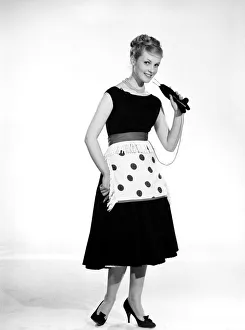 One Young Woman Only Prints: Model Roma Reeves seen here wearing green spot apron whislt knitting 1958 B944-002