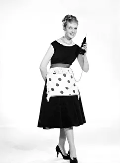 00355 Prints: Model Roma Reeves seen here wearing green spot apron whislt knitting 1958 B944-002