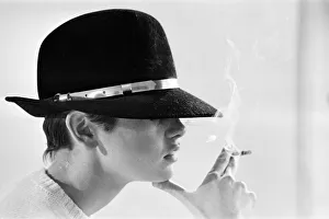 Moody Prints: Model Twiggy posing in the studio wearing a black hat and smoking a cigarette