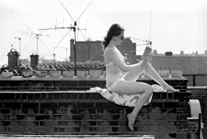 00060 Prints: A model wearing a bikini reading a book as she sunbathes on a rooftop on Kings Road in