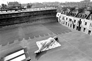 A model wearing a bikini as she subathes on a rooftop on Kings Road in Chelsea, London