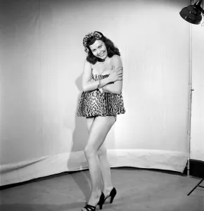 Model wearing leopard skin mini dress and matching muff. 1964