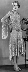 00196 Prints: A model wearing a long patterned dress showing the popular uneven hemline in 1929