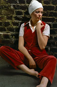 Wall Prints: Model wearing a red velvet waistcoat and trousers with white hat, November 1969