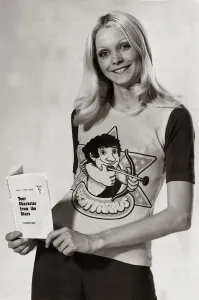 00196 Prints: Model wearing a zodiac sign t-shirt witha cartoon of Sagittarius on it holding a book