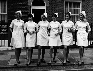 00097 Prints: Models displaying six modern style white dresses for nurses at the London Nursing