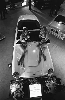 Models pose on the bonnet of a Aston Martin Volante at Motor Show 15th October 1968