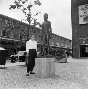 A modern girl in jeans standing next to the statue of Elisabeth Frink by FE McWilliam in