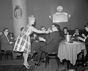 Drivers Prints: Monte Carlo Rally winner Paddy Hopkirk enjoys the attention of a hostess in a Monte Carlo