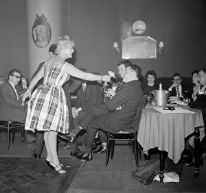 Monte Carlo Rally winner Paddy Hopkirk enjoys the attention of a hostess in a Monte Carlo