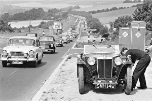 Queue Prints: Mortorist seen here trying to repair his MG as heavy August Bank Holiday traffic