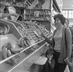 Apples Prints: Mother and daughter buying fresh fruit from a greengrocers stall in Stafford