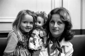 Mother and daughter with girls doll in a cafe on the Champs Elysees in Paris, France