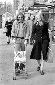 Netherlands Prints: Mother and father pushing their little daughter along in a bugg on the streets of